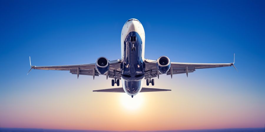 Image of an airplane flying into the sunset 